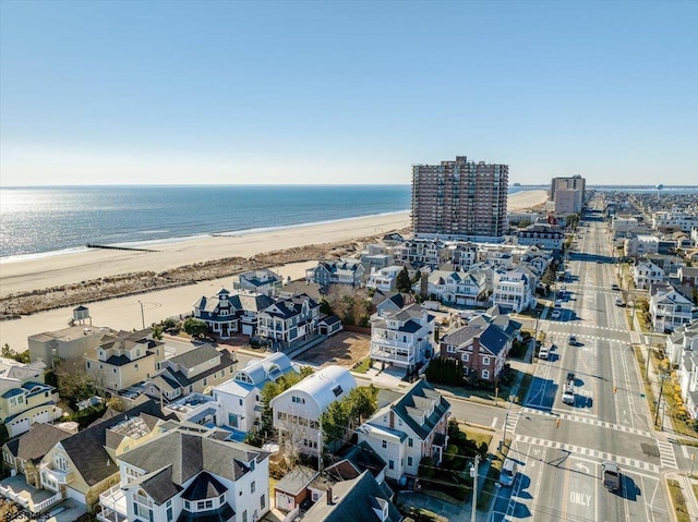 drone / aerial view featuring a residential view, a view of the beach, and a water view