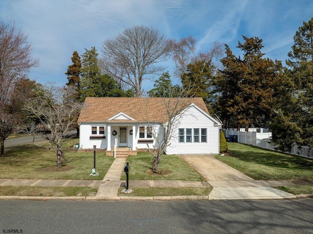 bungalow-style home featuring a front yard and fence