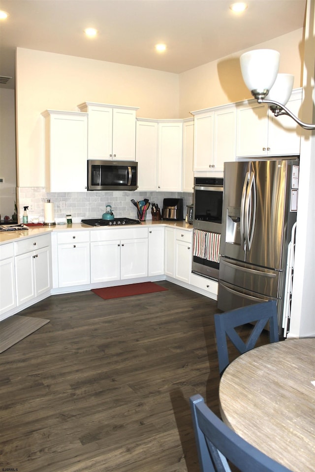 kitchen featuring white cabinets, backsplash, and appliances with stainless steel finishes