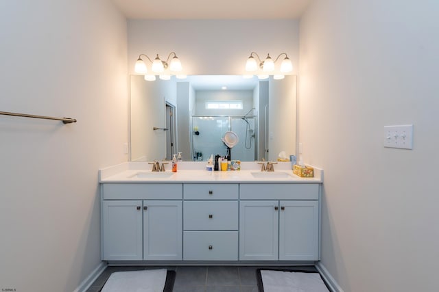 bathroom with a sink, double vanity, a shower stall, and tile patterned flooring