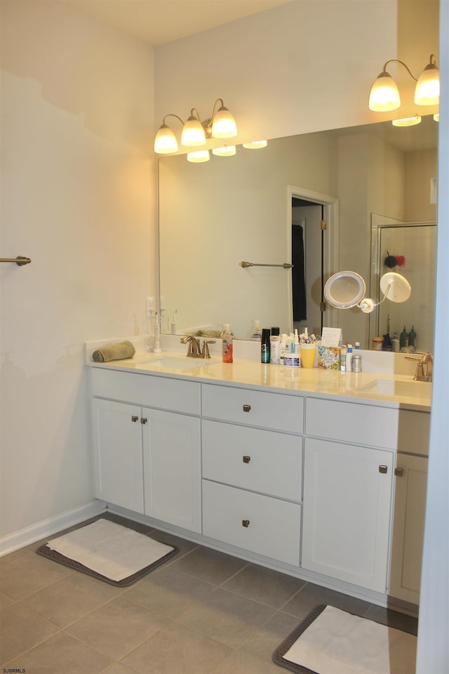 bathroom featuring double vanity, a stall shower, and a sink