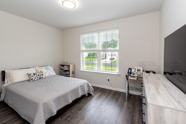 bedroom with baseboards and dark wood finished floors