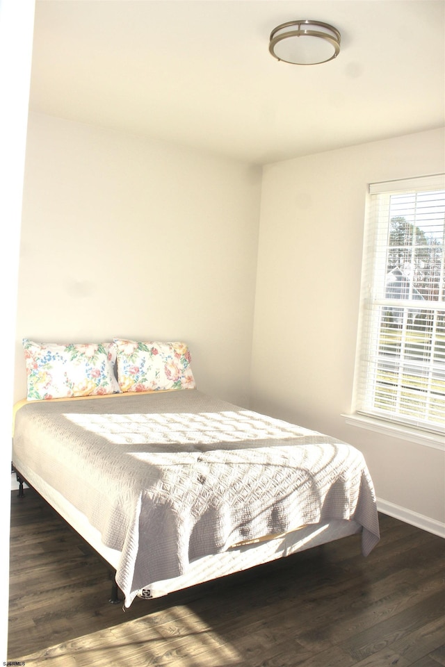 bedroom with baseboards and wood finished floors