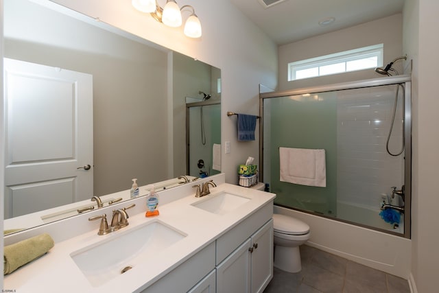 bathroom with tile patterned floors, bath / shower combo with glass door, and a sink