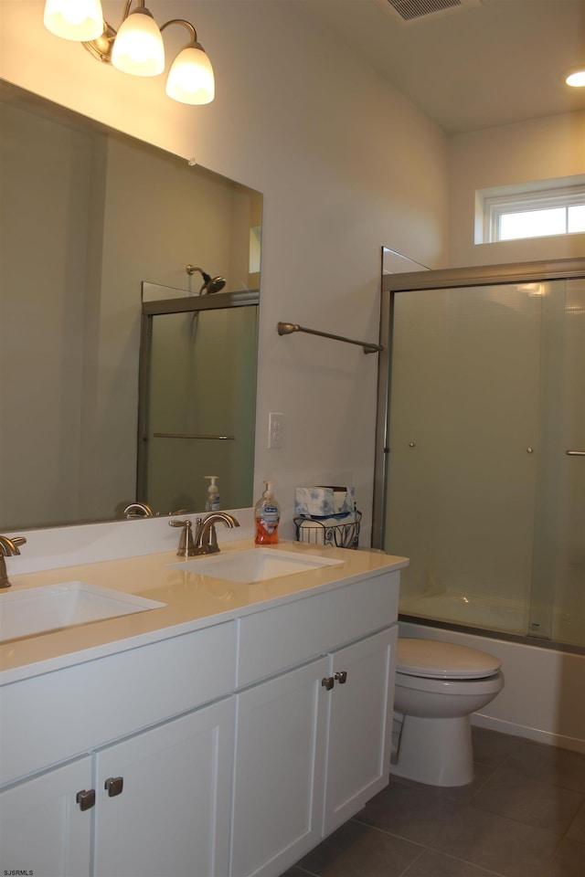 full bathroom featuring tile patterned floors, double vanity, toilet, and a sink