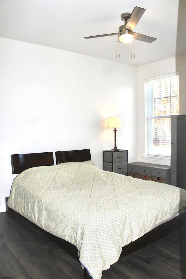 bedroom with a ceiling fan and dark wood-style flooring