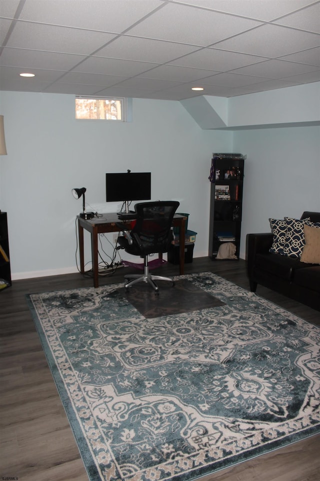 office with baseboards, a paneled ceiling, and wood finished floors