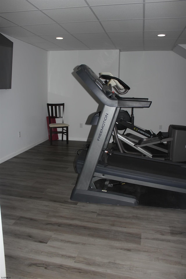 exercise room with wood finished floors, baseboards, and a drop ceiling