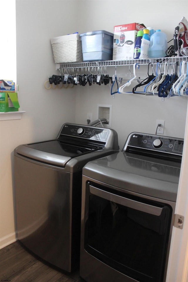 clothes washing area with baseboards, dark wood-style flooring, laundry area, and washing machine and clothes dryer