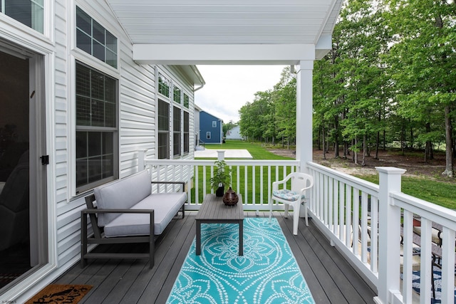 deck with outdoor lounge area and a lawn