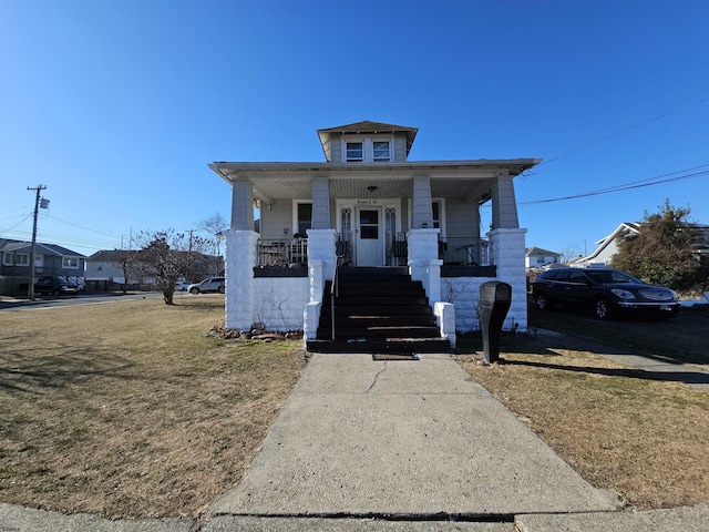 view of front facade featuring covered porch and a front lawn