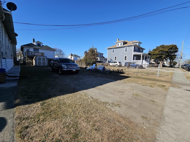 exterior space with a storage shed, an outdoor structure, dirt driveway, and fence