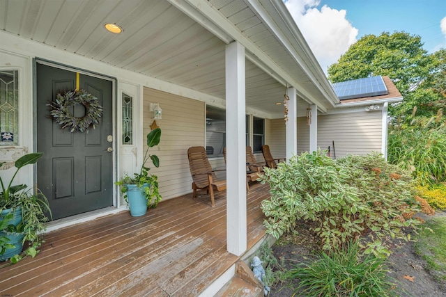 entrance to property featuring covered porch and solar panels