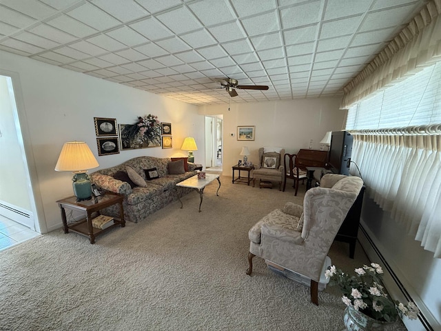 living area with a baseboard radiator, a paneled ceiling, and carpet flooring