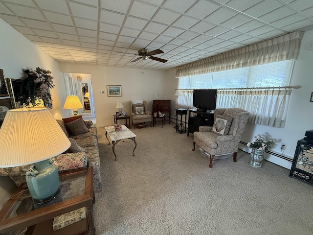 living area with a baseboard radiator, a paneled ceiling, a ceiling fan, and carpet floors