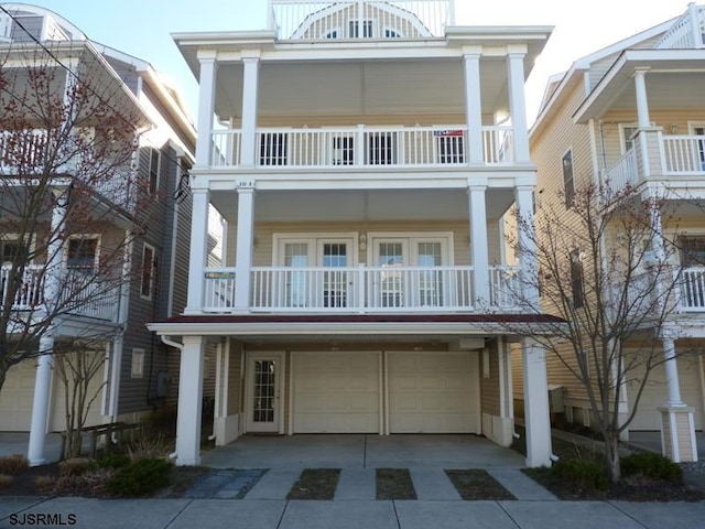 view of front of property featuring a balcony, driveway, and a garage