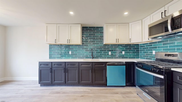 kitchen with a sink, stainless steel appliances, backsplash, and light countertops