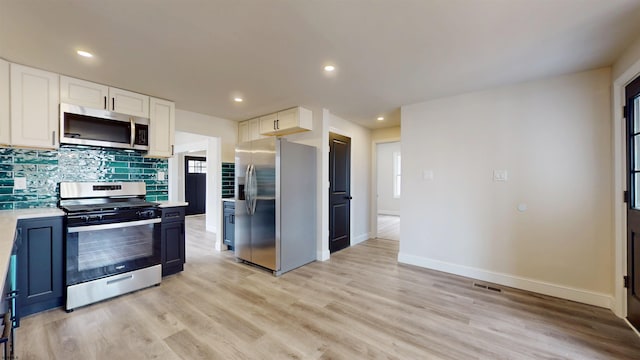 kitchen with light wood-type flooring, white cabinetry, appliances with stainless steel finishes, and light countertops