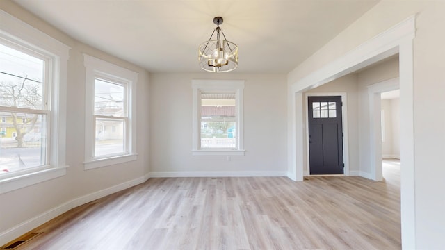 entrance foyer with light wood-style flooring, a notable chandelier, visible vents, and baseboards