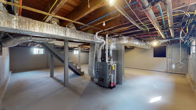 basement featuring heating unit and stairs