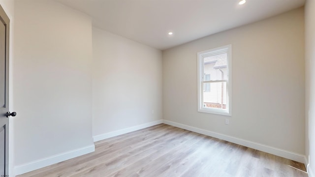 empty room with recessed lighting, light wood-type flooring, and baseboards