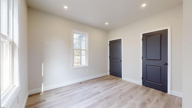 unfurnished bedroom with recessed lighting, baseboards, and light wood-type flooring