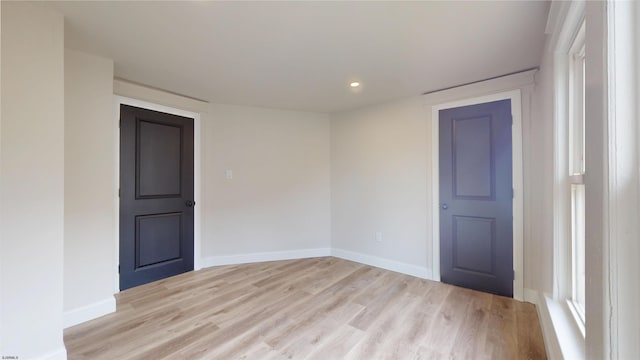 spare room featuring light wood-type flooring and baseboards