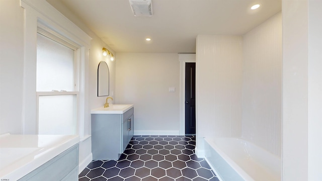 bathroom featuring visible vents, two vanities, recessed lighting, a sink, and a washtub