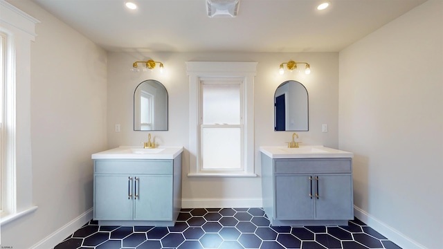 bathroom with two vanities, recessed lighting, and a sink