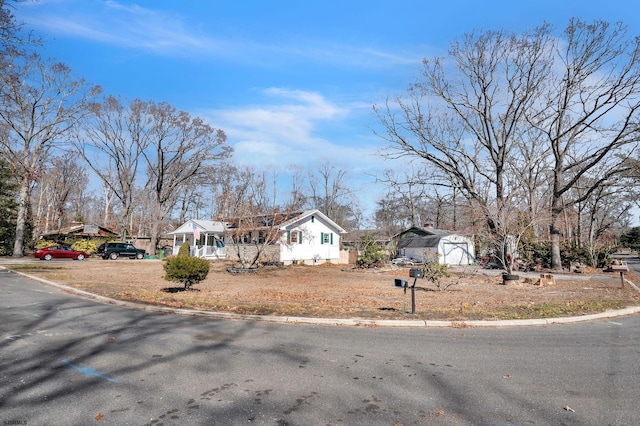 exterior space with a storage unit, a garage, an outdoor structure, and driveway