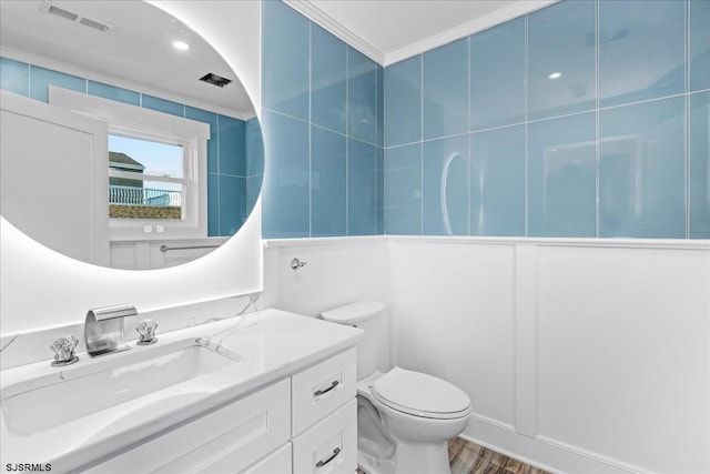 bathroom featuring vanity, wood finished floors, visible vents, crown molding, and toilet