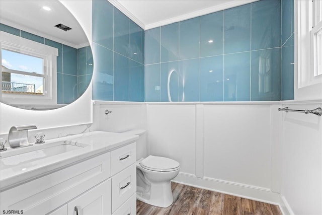 full bath with toilet, vanity, and wood finished floors