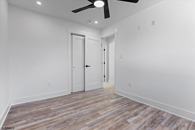 unfurnished bedroom featuring ceiling fan, baseboards, recessed lighting, wood finished floors, and a closet