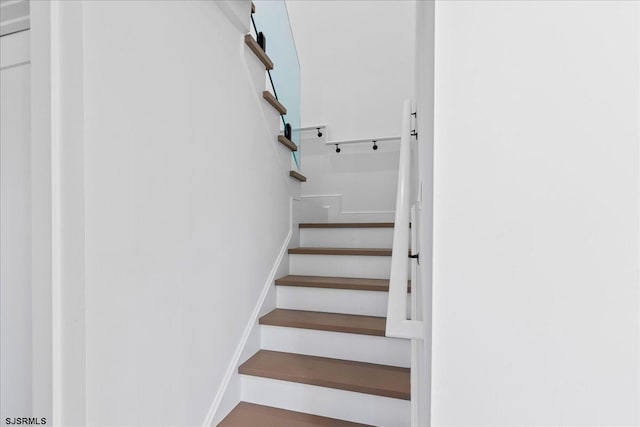 staircase featuring baseboards