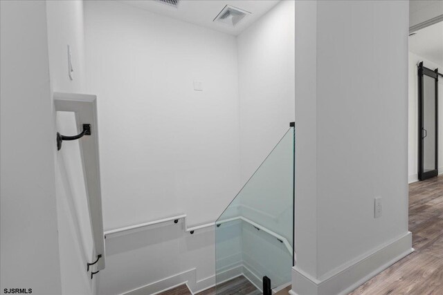 laundry room with wood finished floors, visible vents, and baseboards