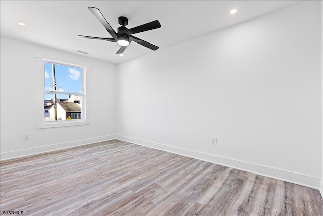 empty room featuring visible vents, light wood-style floors, and baseboards