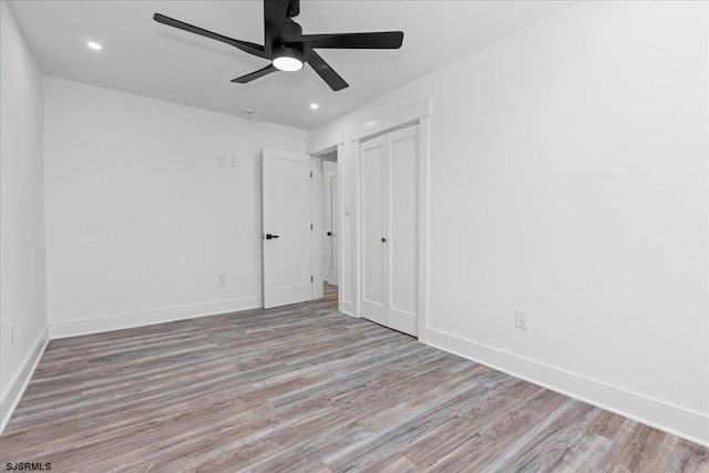 unfurnished bedroom featuring a ceiling fan, wood finished floors, recessed lighting, a closet, and baseboards