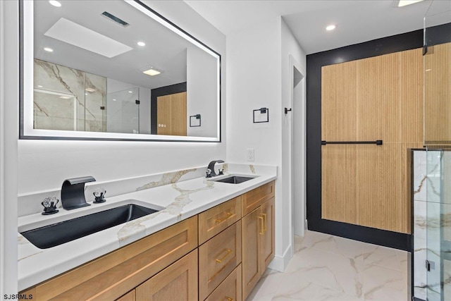 full bath featuring a marble finish shower, recessed lighting, marble finish floor, and a sink