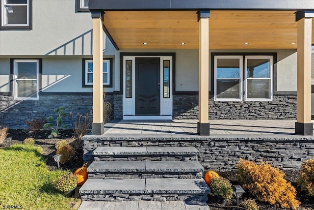 view of exterior entry with stone siding and stucco siding