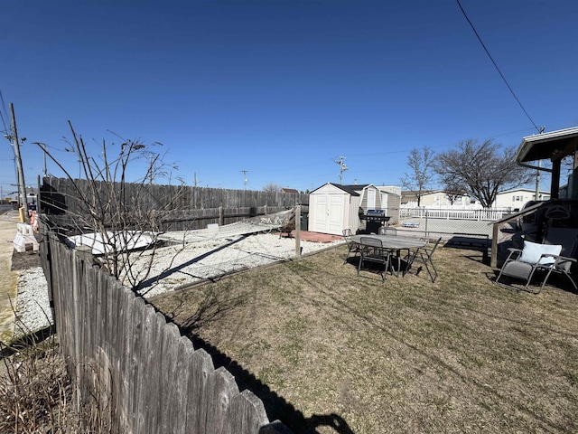 view of yard featuring an outbuilding, a storage shed, and a fenced backyard