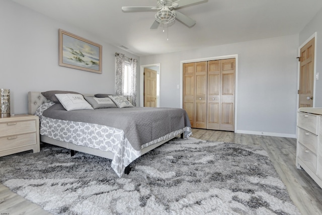 bedroom featuring a closet, baseboards, light wood-style floors, and a ceiling fan