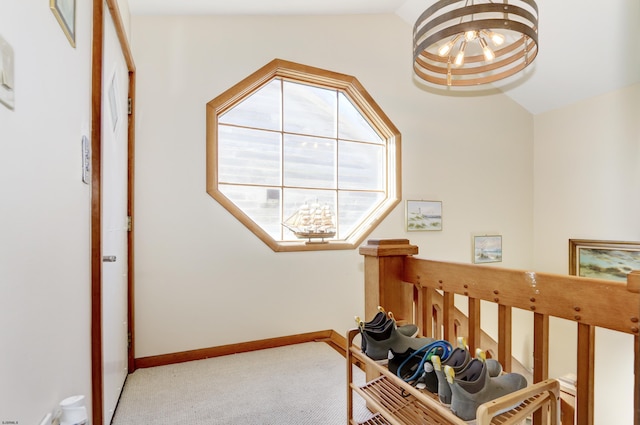 interior space featuring a chandelier, carpet flooring, baseboards, and lofted ceiling