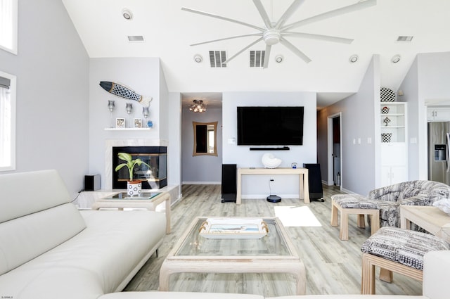 living room with visible vents, a fireplace, and vaulted ceiling