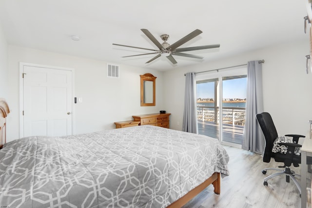 bedroom featuring visible vents, a water view, a ceiling fan, light wood-style floors, and access to exterior