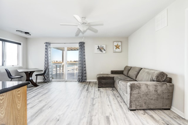 living area featuring visible vents, baseboards, and wood finished floors