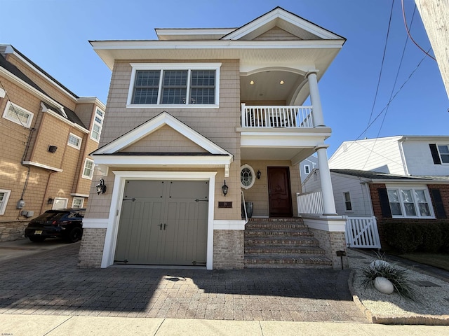 view of front of property featuring a garage, decorative driveway, and a balcony