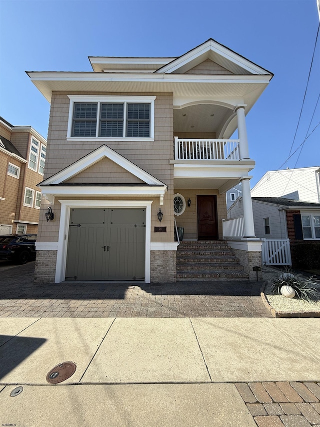 view of front facade with driveway, an attached garage, and a balcony