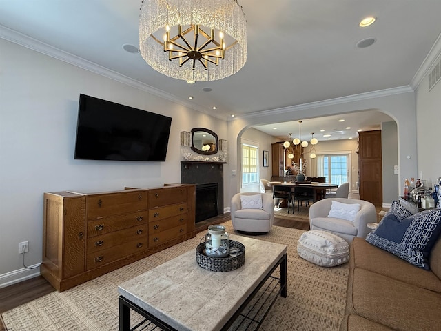 living room with baseboards, an inviting chandelier, light wood-style flooring, a fireplace, and arched walkways