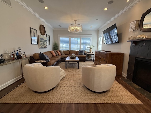 living room featuring visible vents, ornamental molding, a tiled fireplace, wood finished floors, and recessed lighting