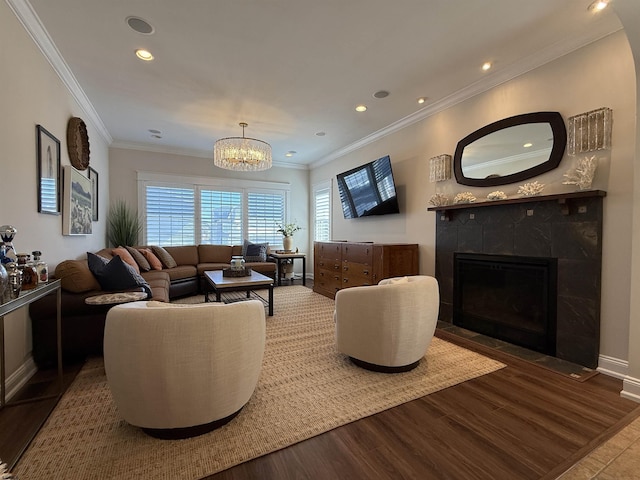 living area featuring a tiled fireplace, recessed lighting, ornamental molding, and wood finished floors